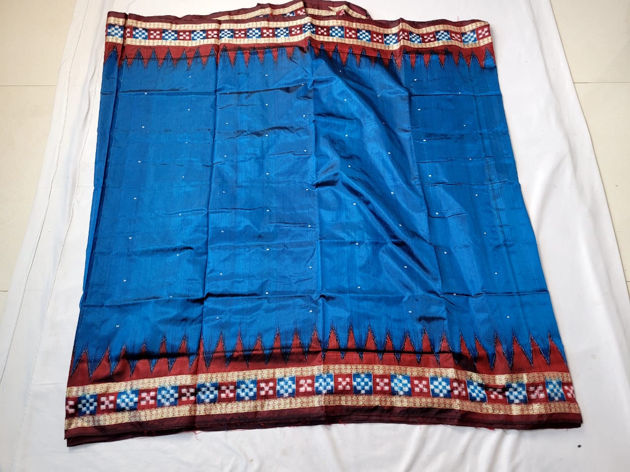 A seree blue and marron  silk patta saree with a plain body adorned with floral designs, complemented by a floral pallu. (Copy)