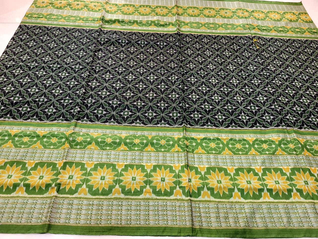 Black and light-green Sambalpuri cotton saree features a whole body and pallu with rounded flowers pattern, fish pattern border, and matching blouse piece.