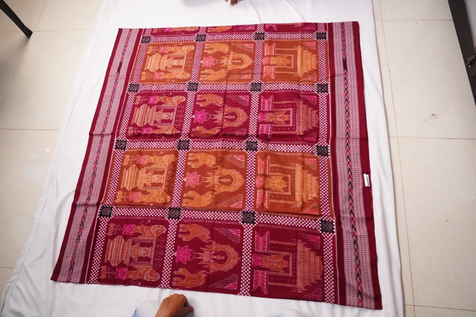 A traditional Sambalpuri cotton saree featuring temple motifs with various animals and lotus designs, complemented by a pallu adorned with floral, tree, and house patterns.