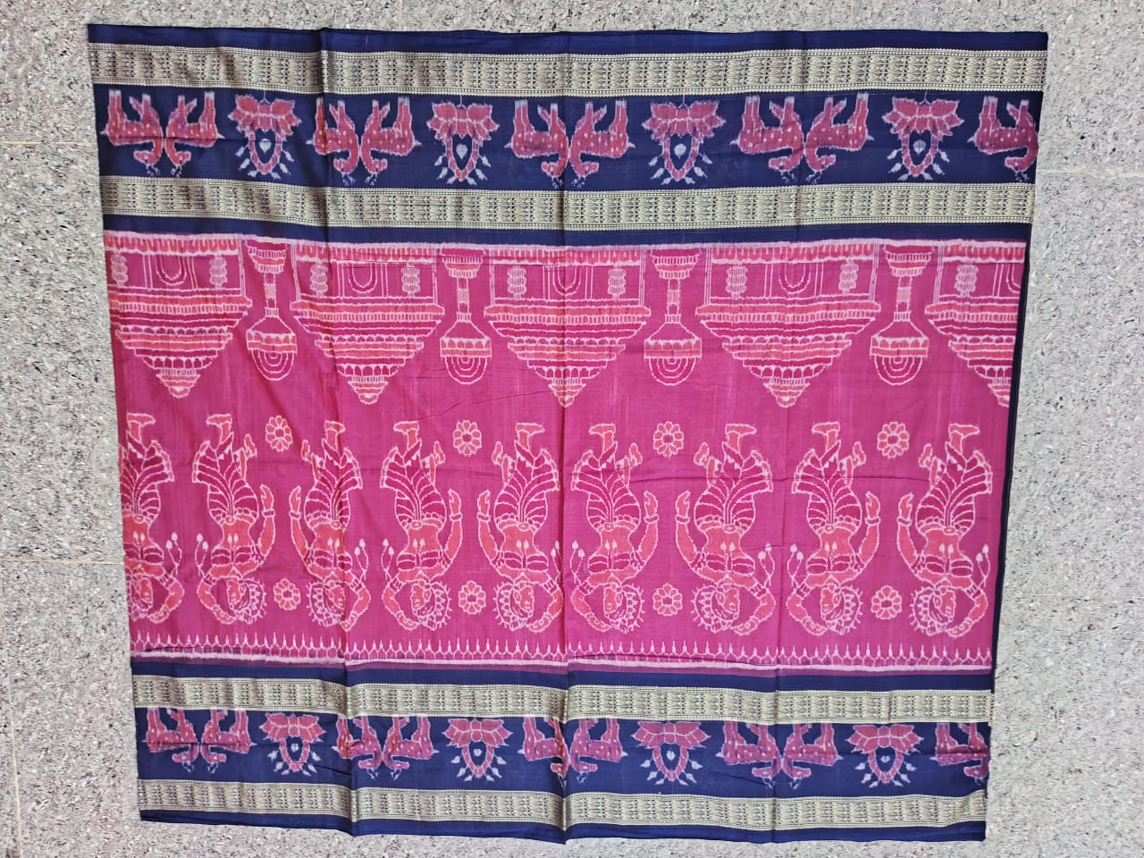 A pink and blue Sambalpuri cotton saree with temple, dancing figures, deer motifs on the body, and round flower designs on the pallu.