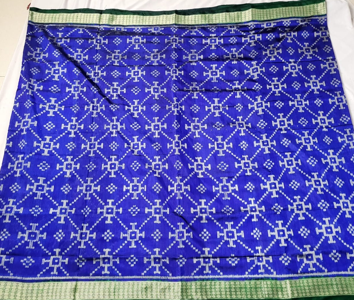 A beautiful blue and green Sambalpuri pata saree with pasapali body pattern and a pallu adorned with big, exclusive floral designs.