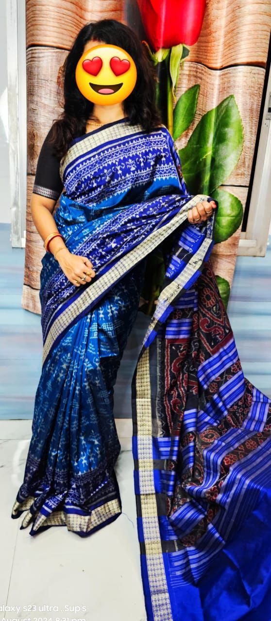 A navy blue and blue patta saree featuring tribal-inspired little man motifs on the body with floral designs elegantly adorning the pallu.