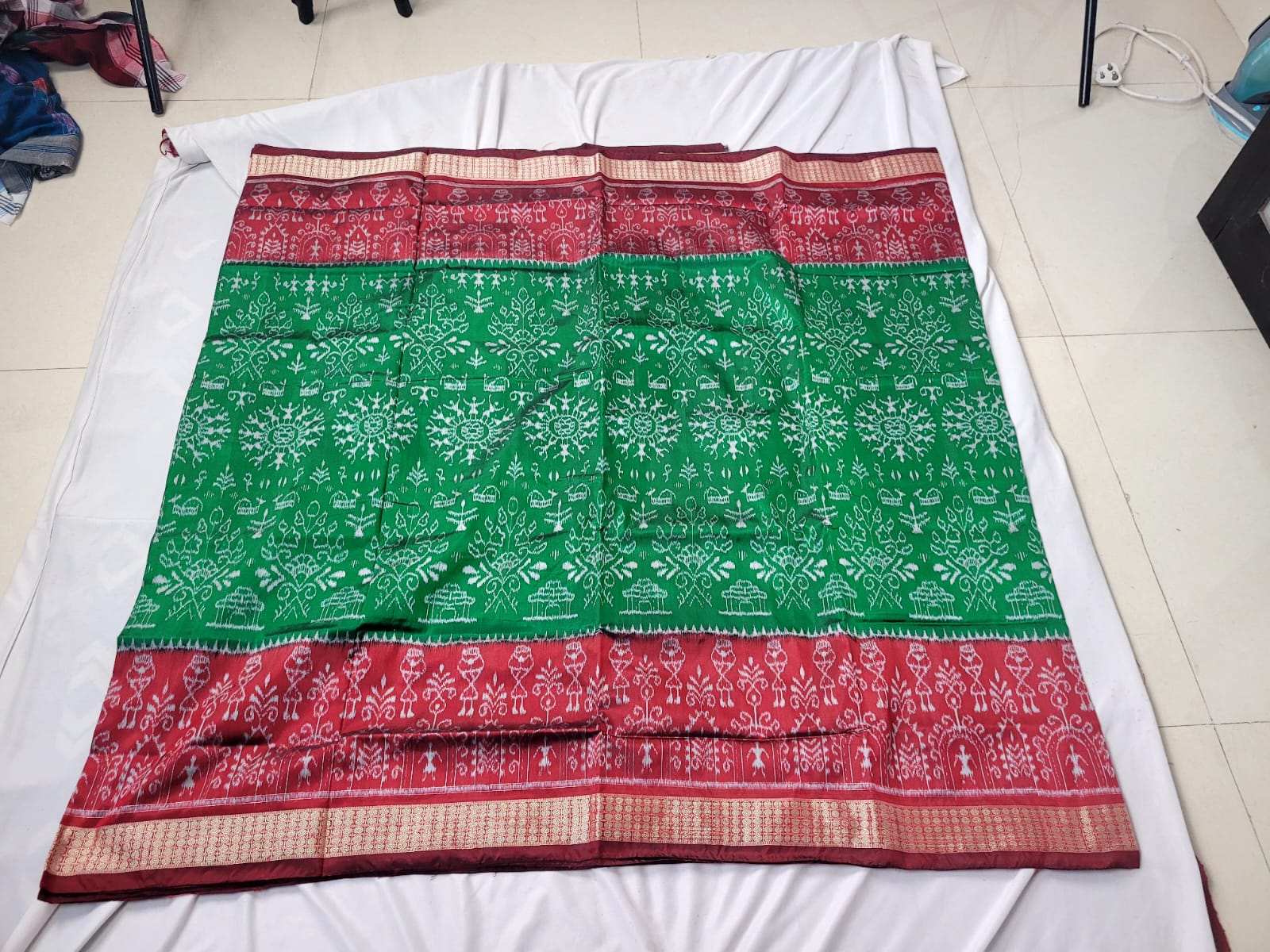 A beautiful green and maroon patta saree featuring mini house, flower, and tree motifs on the body with a Chandua-style pallu design.